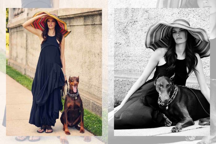Beautiful fashion model in large straw hat and maxi dress with doberman