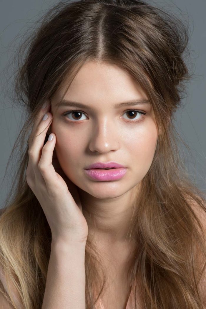 Young model with glowing skin and pink lipstick by Kyrsten Bryant