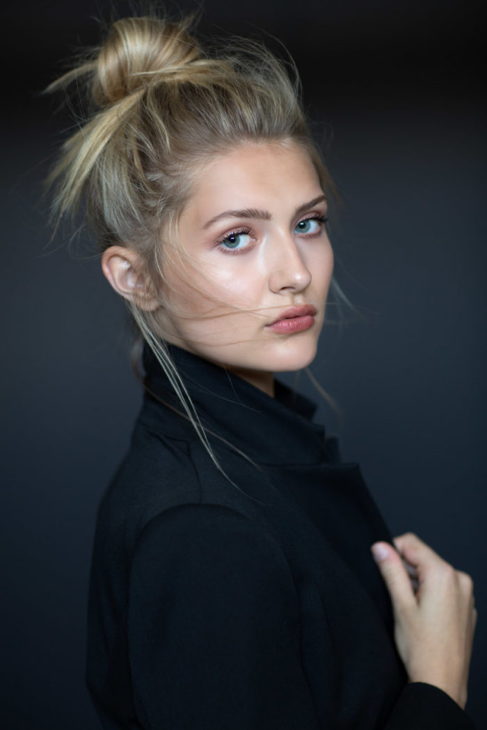 Young blonde woman with messy bun and natural makeup by Kyrsten Bryant