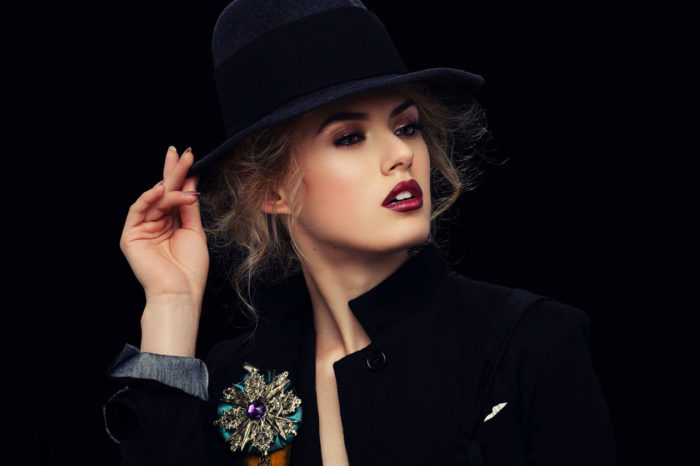 Glamorous woman in hat with red lipstick and bronze eye makeup by Kyrsten Bryant