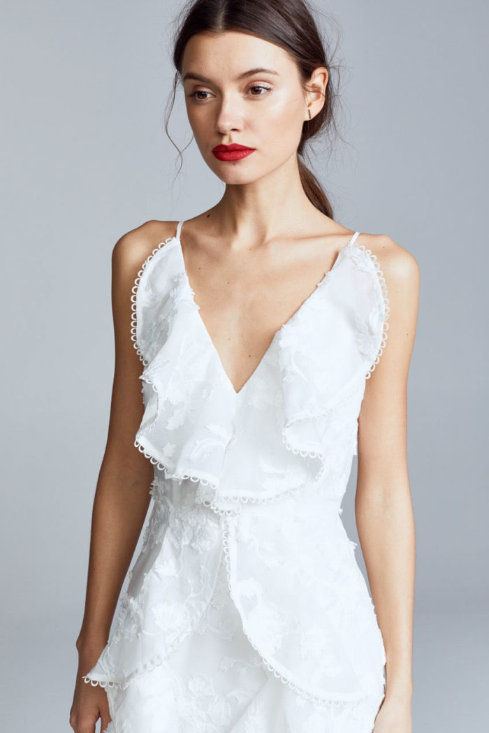 Model in white dress with red lipstick and makeup by Kyrsten Bryant