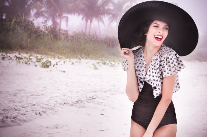 Woman on beach in vintage bathing suit and red lipstick by Kyrsten Bryant